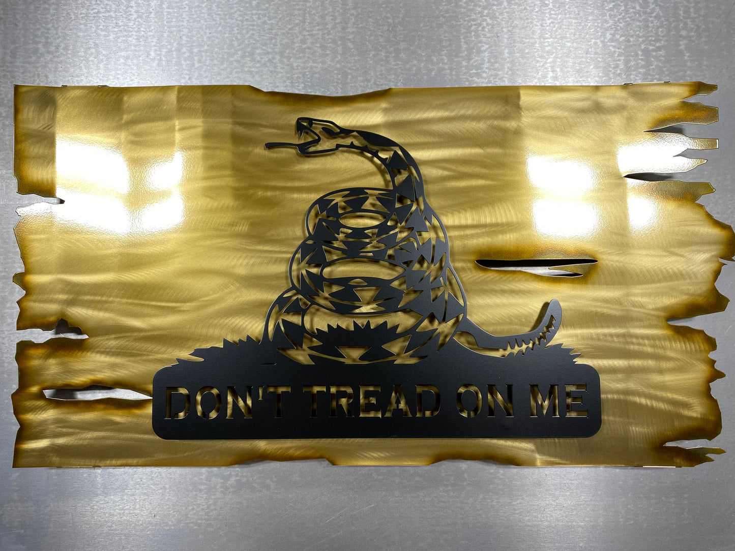 Distressed yellow metal Gadsden flag with Don’t Tread on Me design