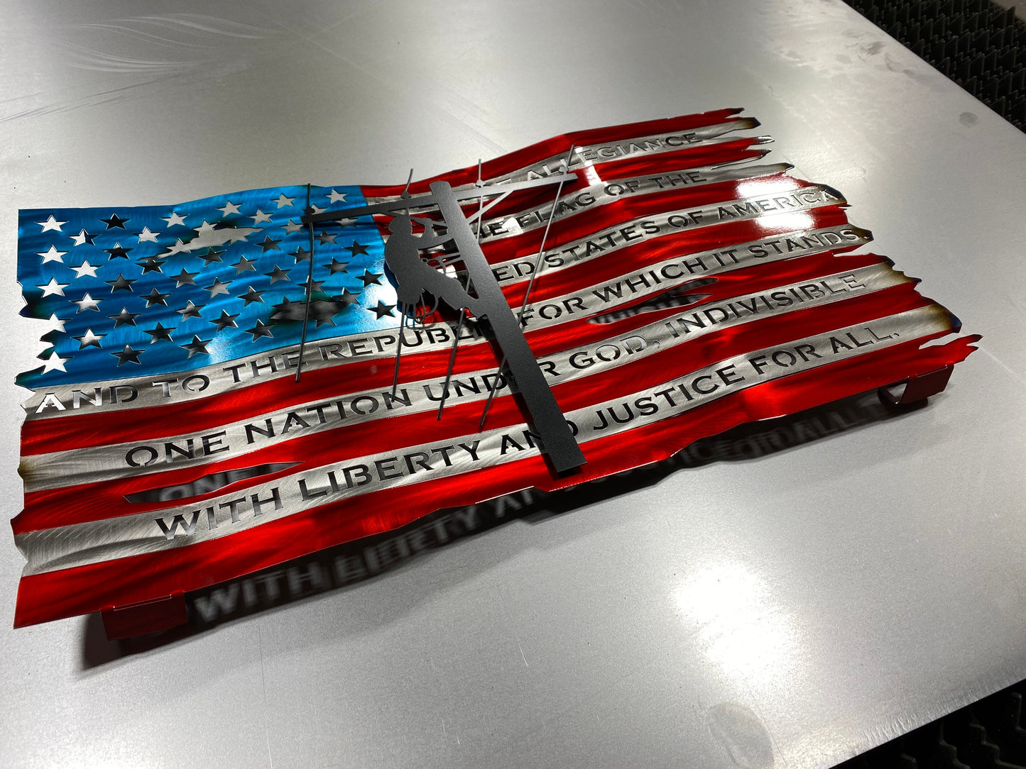 Distressed metal lineman flag with Pledge of Allegiance, crafted from American steel with wave pattern and powder coat finish