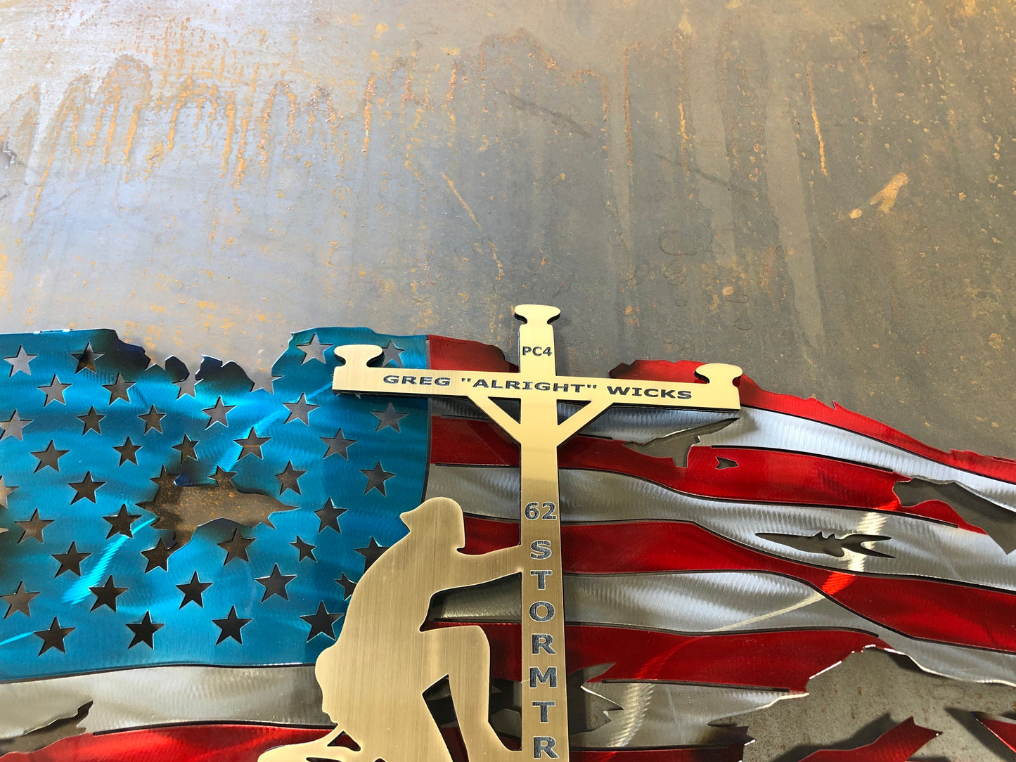 Lineman American Flag featuring a wavy battle-worn metal design with a customizable floating gold lineman. Engraved details available.