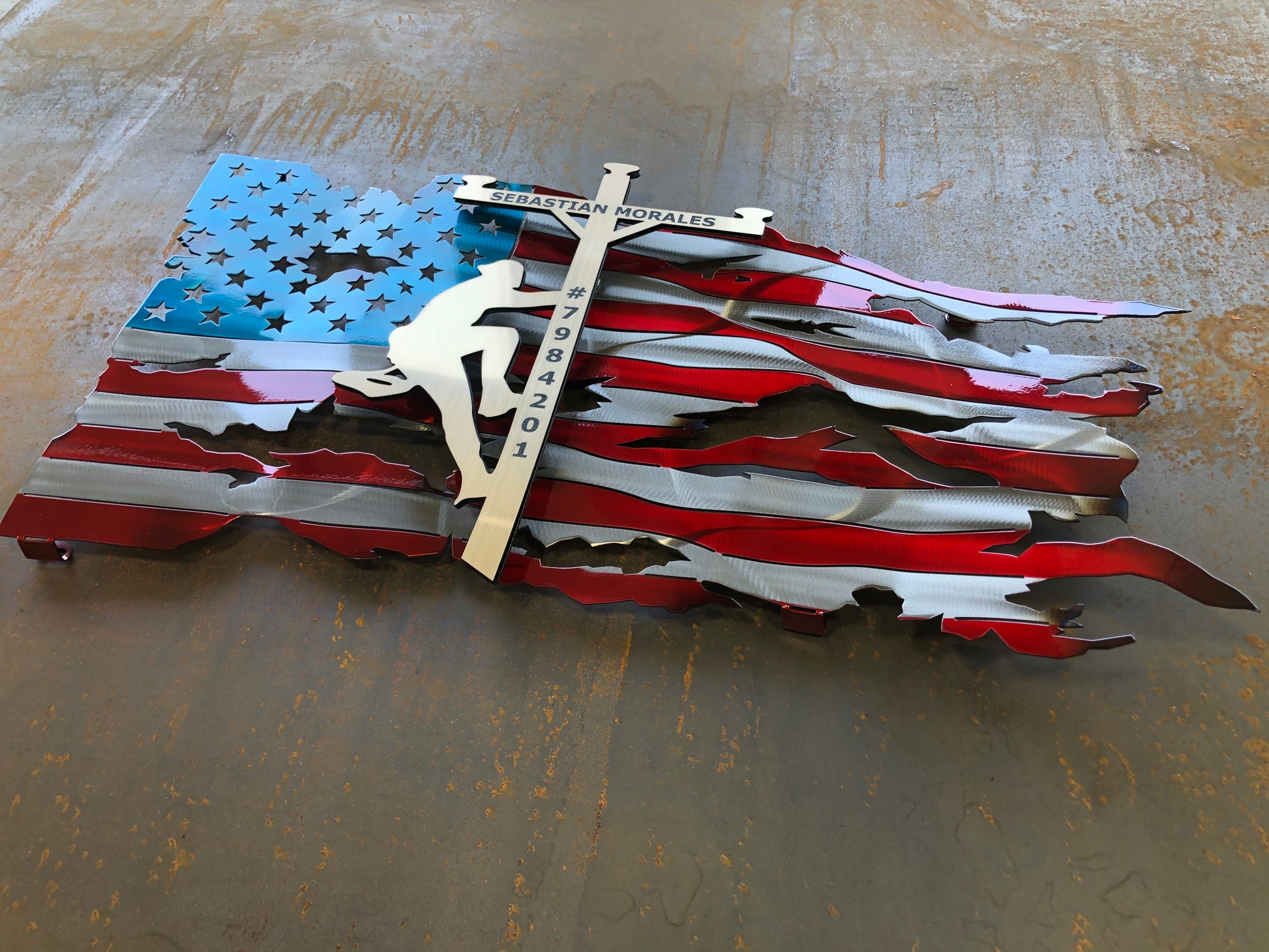 Lineman American Flag featuring a wavy battle-worn metal design with a customizable floating gold lineman. Engraved details available.