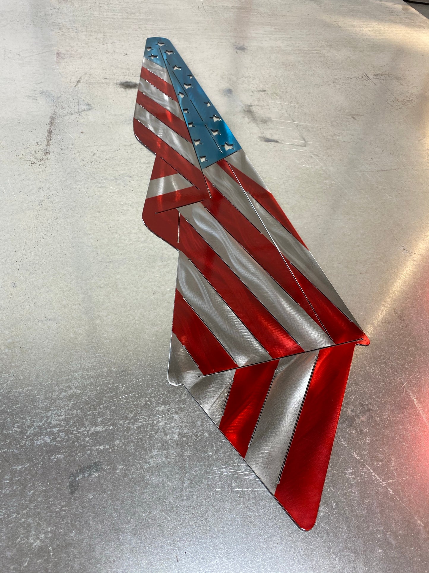 Metal Draped American Flag, handcrafted from American steel with a grind pattern and three-stage powder-coated finish by CnS CnC.