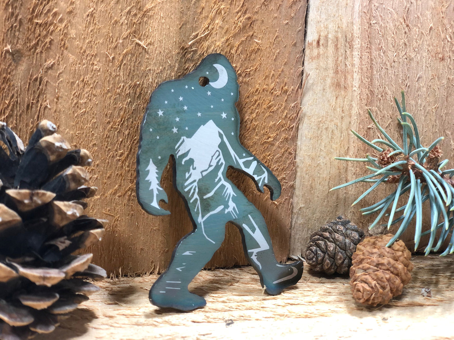 Sasquatch Keychain, handcrafted metal keychain featuring laser-engraved Bigfoot design, nighttime landscape, and clear powder coat finish by CnS CnC.