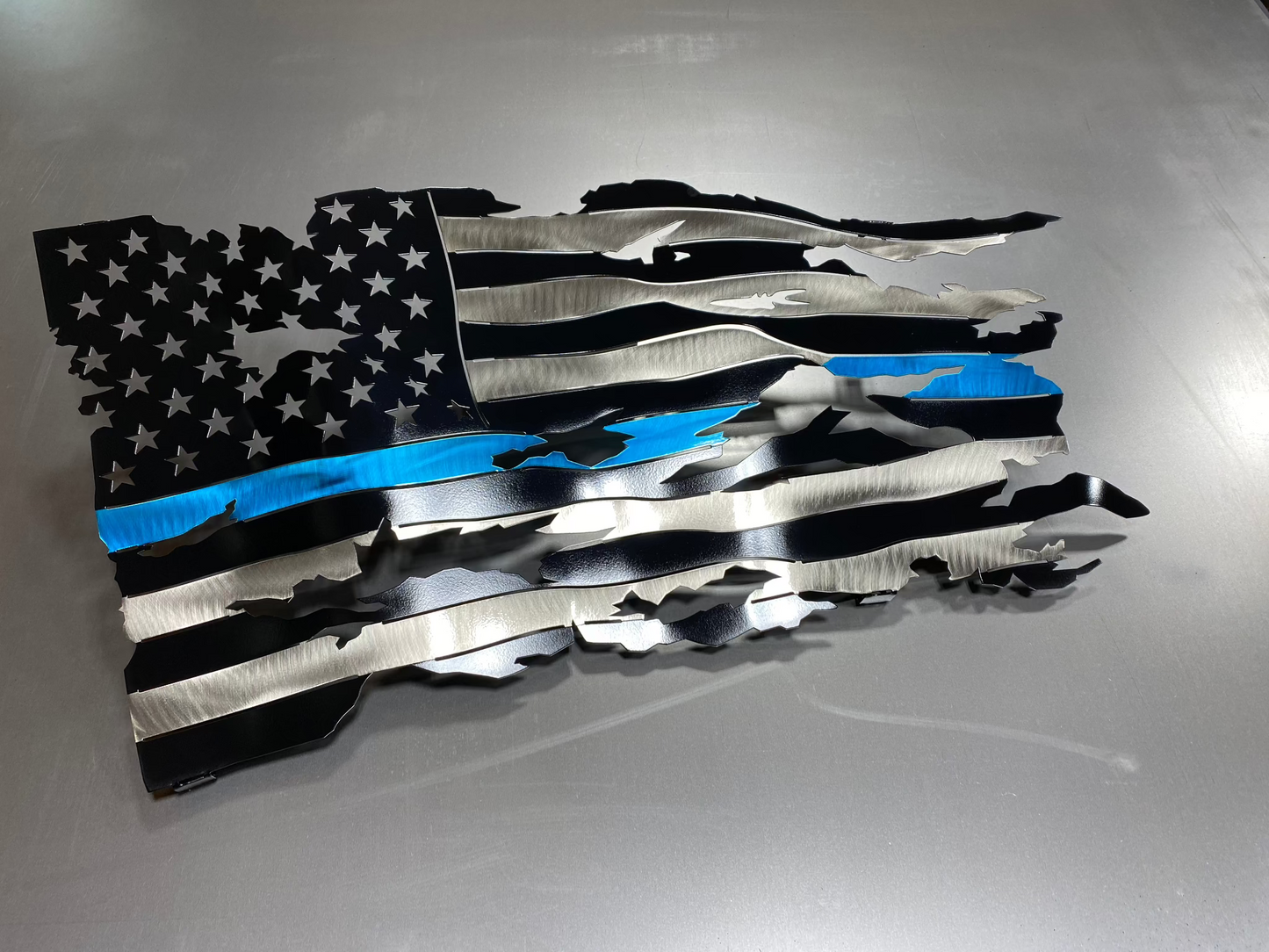 Thin Blue Line wavy metal flag, hand-formed with a three-stage powder-coated finish, measuring 24 inches wide.