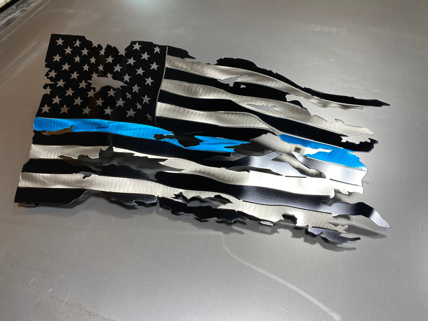 Thin Blue Line wavy metal flag, hand-formed with a three-stage powder-coated finish, measuring 24 inches wide.