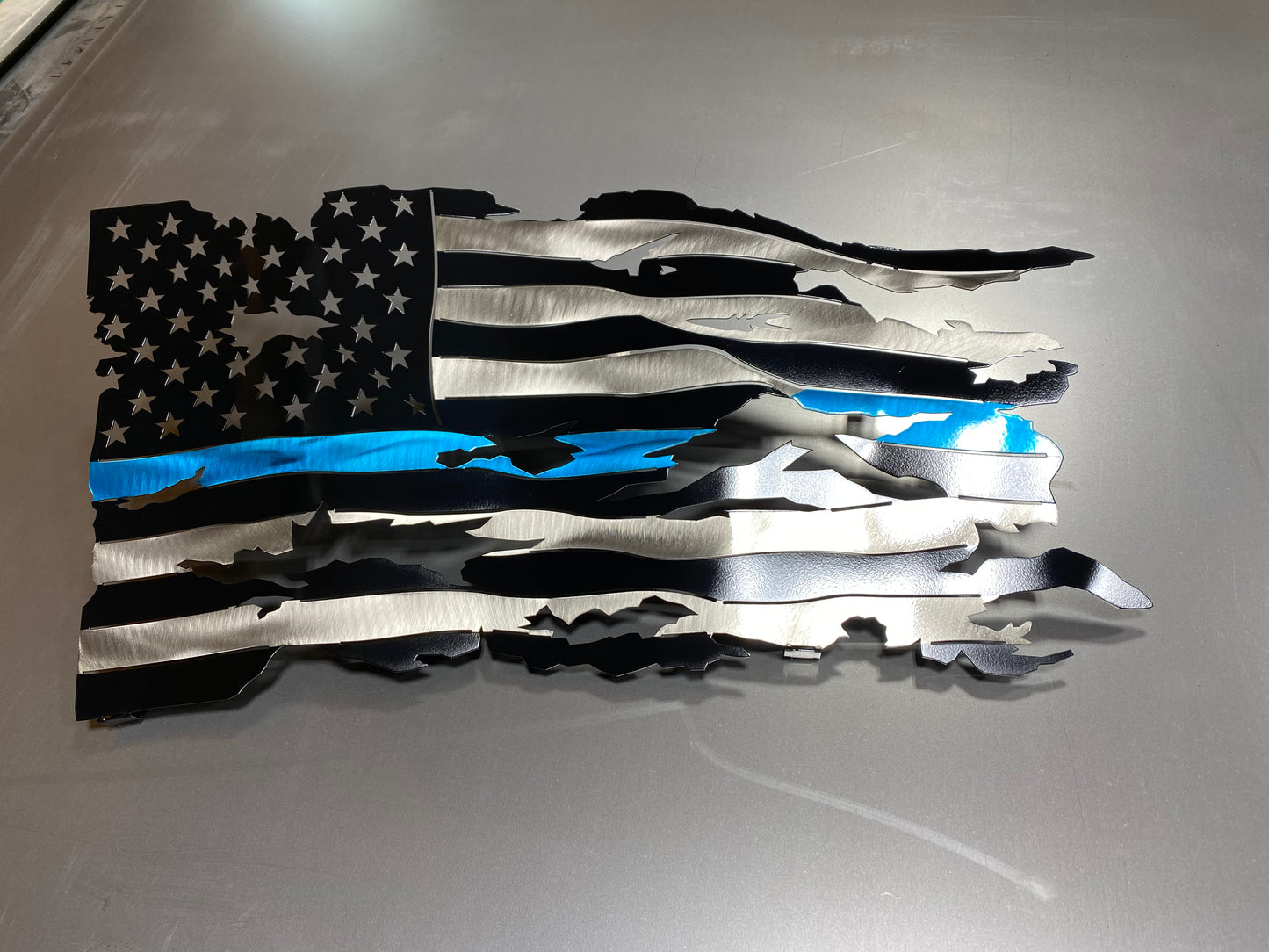 Thin Blue Line wavy metal flag, hand-formed with a three-stage powder-coated finish, measuring 24 inches wide.