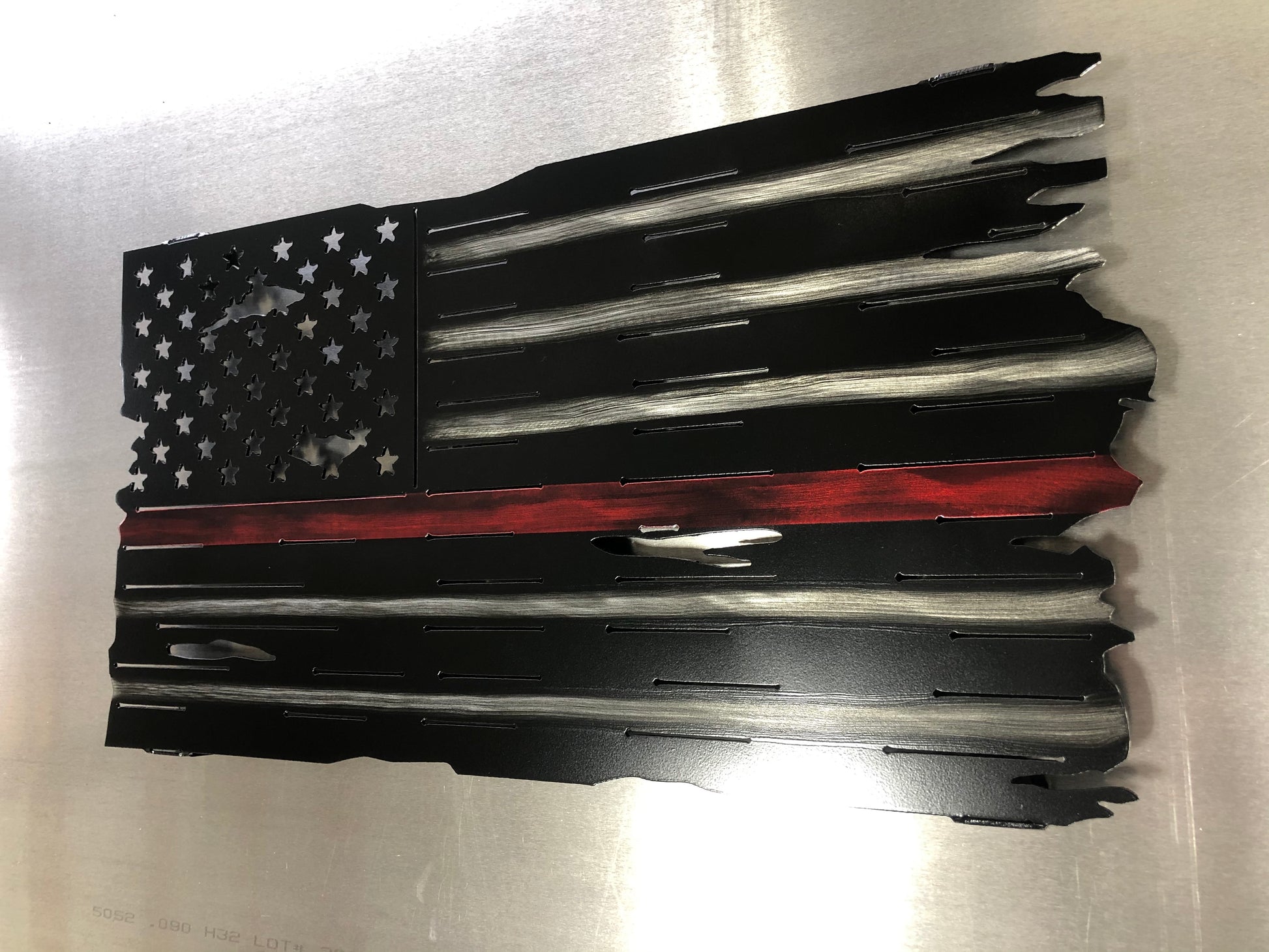 Thin Red Line Distressed American Flag made from metal, featuring a rugged design honoring firefighters. Perfect for home or station display.