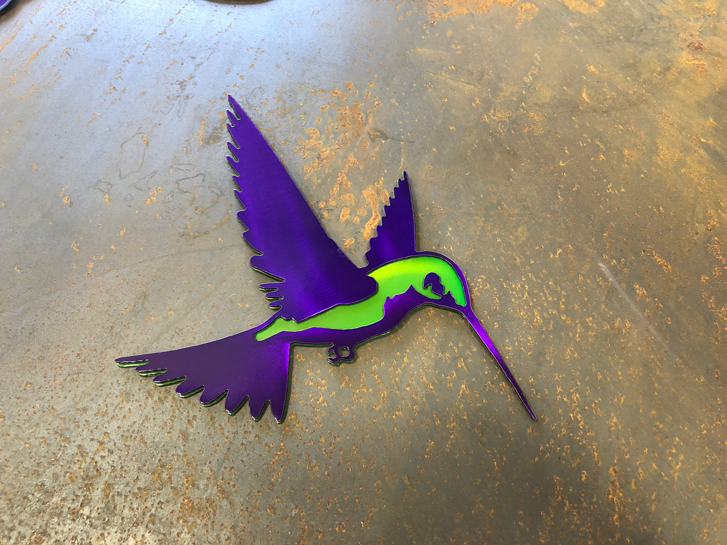 Colorful metal hummingbird wall art in candy grape and lime finish, 9.75x8 inches, with layered steel design and integrated hanger