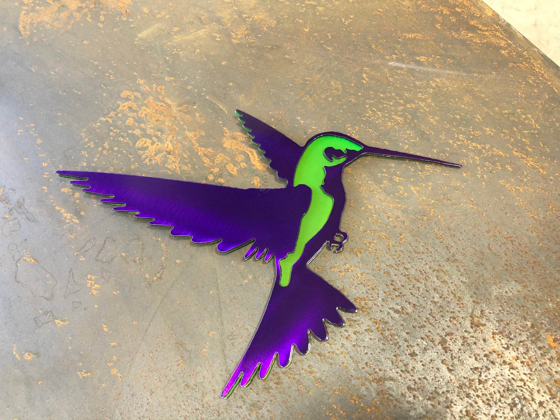 Colorful metal hummingbird wall art in candy grape and lime finish, 9.75x8 inches, with layered steel design and integrated hanger