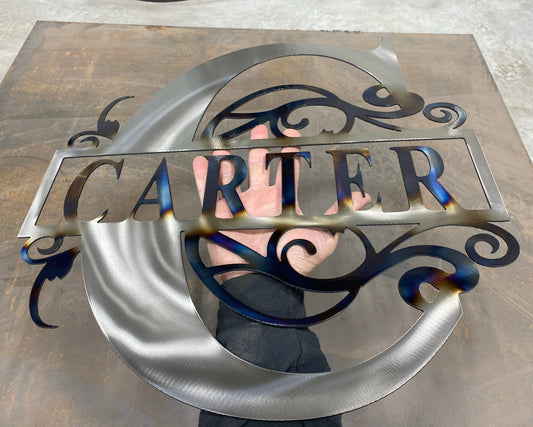 Get a custom Split Letter Family Name Monogram, laser-cut from 14-gauge steel, heat-treated for blue and gold hues, and powder-coated for durability.