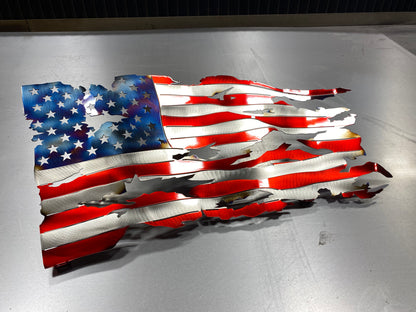 Battle-worn waving metal American flag with heat patina accents, handcrafted and powder-coated in Candy Red for indoor and outdoor display by CnS CnC