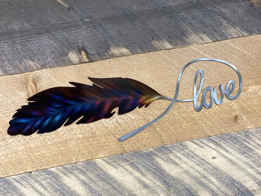 Love Feather metal wall art, handcrafted from American steel, heat-treated for blue and purple hues, and finished with a clear powder coat by CnS CnC.